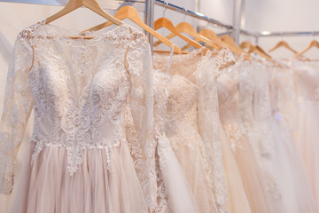 Beautiful lace wedding dresses on hangers in the showroom.