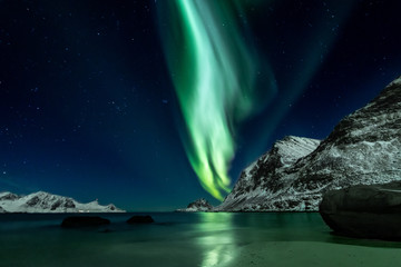 Fototapeta na wymiar Beautiful green Northern Lights at Haukland Beach on the Lofoten Islands in Norway