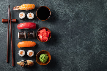 Set of sushi and maki on stone table.