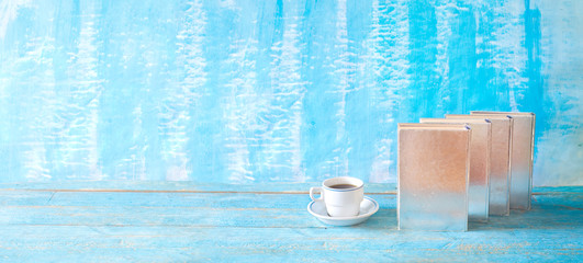 row of multicolored silver shiny hardback books and cup of coffee, panorama, reading, education, literature, good copy space