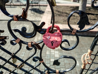 Forged bridge for lovers with wedding locks in the shape of a heart. Many wedding locks.