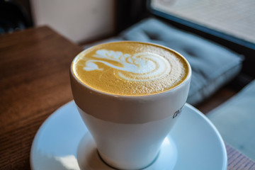 Fresh and fragrant coffee in coffee shop. A cappuccino cup with the drawing of a swan. Latte art. The invigorating drink.