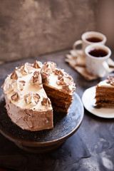 Homemade Kiev cake, dacquoise cake with butter cream and hazelnuts. Gradient  layers in brown shades