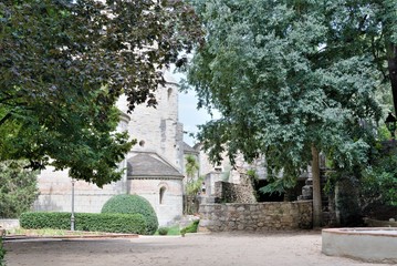 Fototapeta na wymiar Girona, Spain, August 2018. Park inside the fortress wall, trees and view of the medieval cathedral.