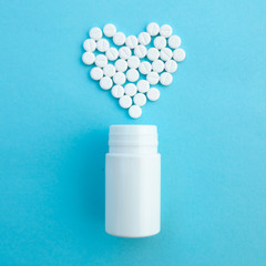 medicine, healthcare and pharmacy concept - pills and of drugs in shape of the heart