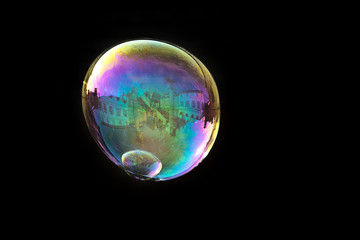 Soap bubble reflecting the architecture of Udine city, Friuli Venezia Giulia region, Italy