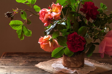 Red rose in vase on wooden table