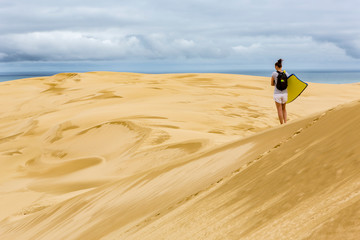 Woman with sandboard Giant sand dunes, Te Paki, Northland, North Island, New Zealand © Beautyness