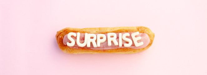 Surprise word written in eclair voluminous white letters on a beautiful pink background.