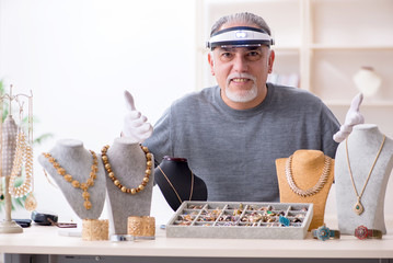 White bearded old jeweler at workshop 