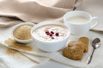 Sesame dry cookies in the form of heart, porridge of amaranth and yogurt, healthy breakfast.