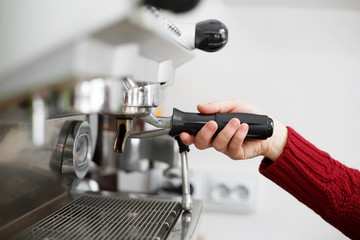 close-up of a barista hand installs a coffee cup for coffee maker