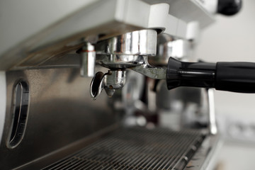 Fototapeta na wymiar Stainless steel cooking appliance to brew coffee. Parts of coffee machine. Closeup coffee machine holder installed in machine