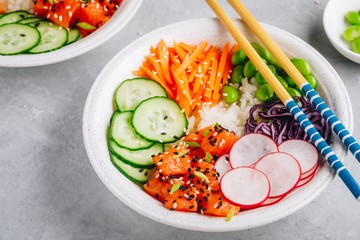 Salmon poke bowl with rice, radish,cucumber, carrots, edamame, red cabbage