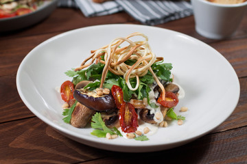 Grilled eggplant salad, tomatoes, mushrooms, cheese sauce, Cecil smoked cheese, fresh herbs. Wooden background
