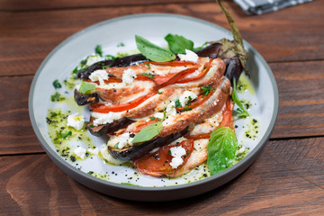Fan of eggplant, meat stew, tomatoes, cheese, delicious Italian dish. Wooden background