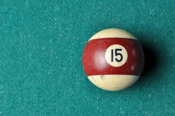 Old billiard ball number 12 striped white and brown on green billiard table, copy space