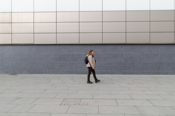 Blonde caucasian woman is walking outdoors