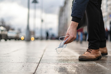 person pick up dropped trash in the streets