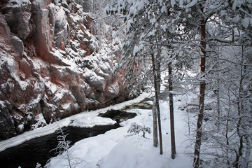 Fototapeta na wymiar Frozen Patoniva River and red rocks of Oulanka National park, Finland