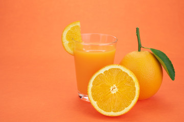 Orange juice and oranges with leaves