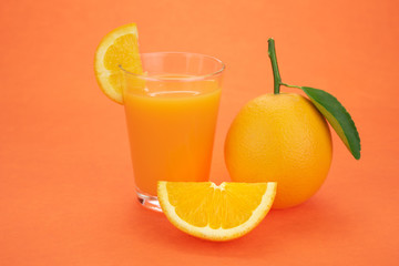 Orange juice and oranges with leaves