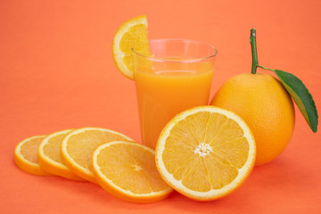 Orange juice and oranges with leaves