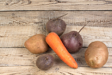 Organic vegan food. potato, beet, carrots on wooden background. country style.