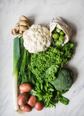 Healthy vegan ingredients for cooking. Various clean vegetables and herbs on marble background. Products from the market without plastic. Flat lay