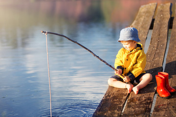 Boy on wooden dock with a fishing net