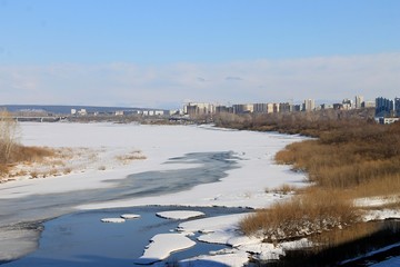 river in the ice on the background of the city under construction