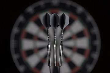 3 darts on dartboard background. dart board blurred