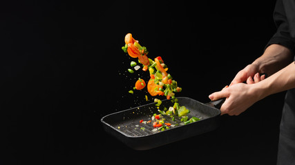 Professional chef. cooks vegetables in a pan, Asian cuisine. Eastern. A recipe book. Delicious healthy food