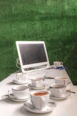 Office desk with computer, supplies and coffees.