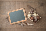 Easter holiday background with brown easter eggs decorations and chalkboard on wooden table.