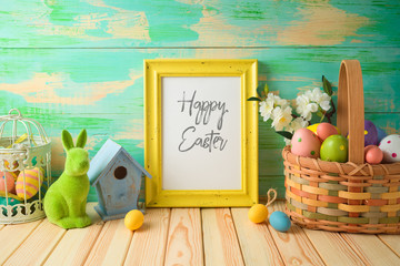 Photo frame or artwork display mock up on wooden table with easter decorations.