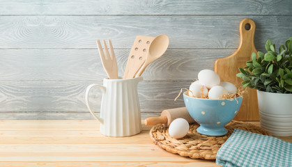 Fototapeta na wymiar Easter baking background with eggs and kitchen utensils on wooden table