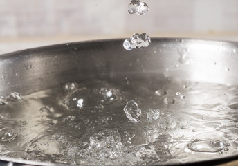 Boiling water in a metal pan close-up