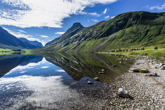 Mountain and sky reflected in Eidsvatnet lake near Geirangerfjord in a bright summer day, Sunnmore, More og Romsdal, Norway