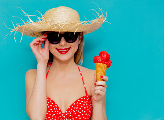 Young woman in red bikini and straw hat with ice cream