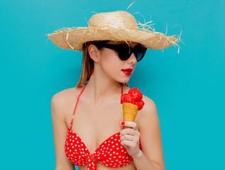Young woman in red bikini and straw hat with ice cream