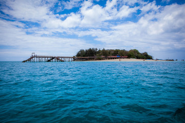View to Prison (Changuu) Island and wooden pier from a boat in turquoise Indian Ocean