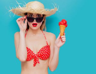 Young woman in red bikini and straw hat with ice cream