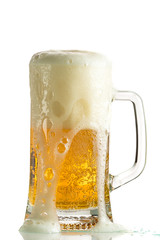 Pouring light beer in a beer mug, it turns out foam and spray