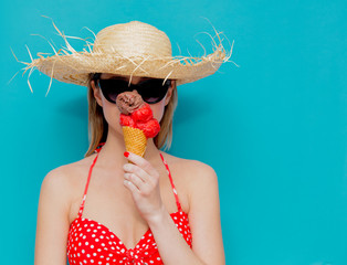 Young woman in red bikini and straw hat with ice cream