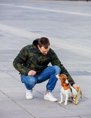 man with his dog, Jack Russell Terrier, on the city street