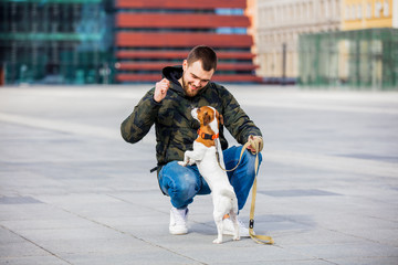 man with his dog, Jack Russell Terrier, on the city street