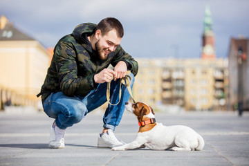 man with his dog, Jack Russell Terrier, on the city street