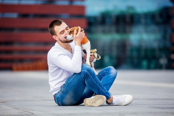 man with his dog, Jack Russell Terrier, on the city street