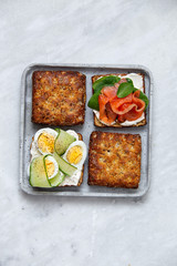 Smorrebrod - danish open sandwich with fish, vegetables, cheese on marble background. Top view with copy space